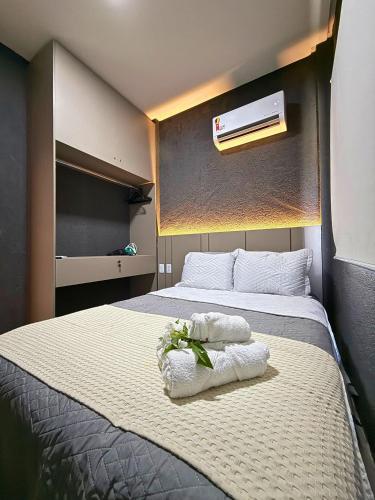 a bedroom with a bed with towels on it at MHV Milagres - Studio Guadalupe 05, quarto e sala privativo a poucos metros da Praia do Marceneiro in Passo de Camarajibe