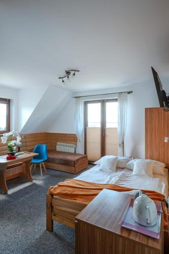 a hotel room with a large bed and a table at Ziaciówka Noclegi Premium w Górach in Rzepiska