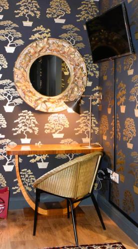 a mirror on a wall next to a table with a chair at BnB at Number 8 in Arundel