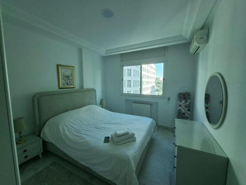 突尼斯Lac 2 Luxury apartment C的一间卧室，有一张白色的床和一扇窗户