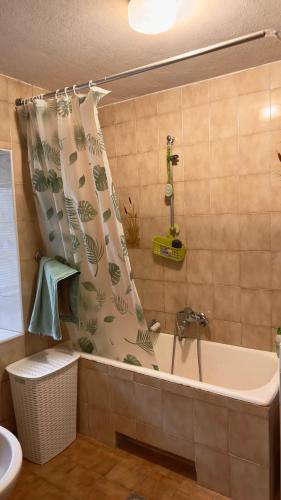 a bath tub in a bathroom with a shower curtain at Room Pstina in Slap ob Idrijci