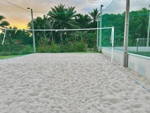 a volleyball court with a net on top of sand at Refúgio na praia - Ap para locação por temporada in Parnamirim