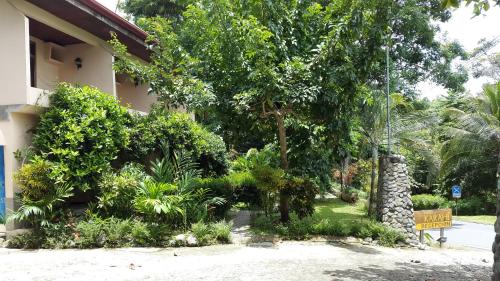 a garden outside a building with trees and plants at Karahe Beach Hotel in Manuel Antonio