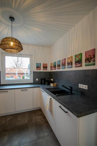 a kitchen with white cabinets and a large window at betterplaces Homes - Frontenhausen in Frontenhausen