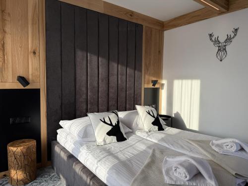 ein Schlafzimmer mit einem großen Bett mit weißen Laken und Kissen in der Unterkunft GreenHill Bachleda in Zakopane