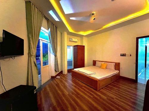 迪石Nhà Nghỉ Thành Đạt - Bến Tàu Phú Quốc的房间里有一张床和一台电视的卧室