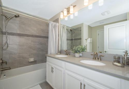 a bathroom with two sinks and a shower at 4964RS TOWNHOUSE 4 BEDROOMS & 3 BATHROOMS + POOL in Kissimmee