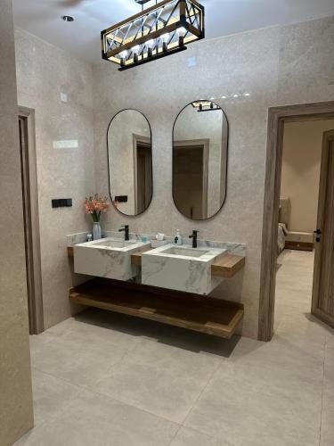 a bathroom with two sinks and a large mirror at Alwadi view شرفة الوادي in Nizwa