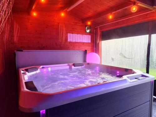a large hot tub with purple lights in a room at Le Rensy in Ferrières