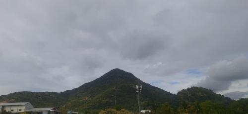 a mountain in the distance with clouds in the sky at Paripuranam in Tiruvannāmalai