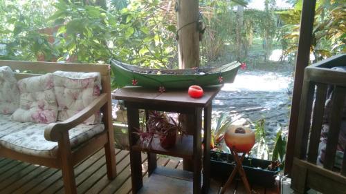 a toy boat sitting on a table on a porch at Pousada das Gêmeas in Ilha do Mel