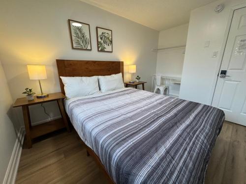 a bedroom with a large bed with a striped blanket at North Barrie !E Stylish and Cozy Private Bedroom with Shared Bathroom in Barrie