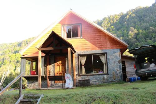 ein Haus mit einem davor geparkten Auto in der Unterkunft 10 hectáreas de montaña con cabaña, senderos, saltos de agua y más in Curacautín