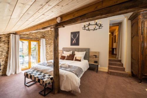 a bedroom with a bed and a stone wall at Gîte de Prestige dans un Fort, Jacuzzi, 8 pers in Leynhac