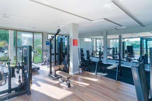Un gimnasio con varias cintas de correr y máquinas en una sala. en Apartamento completo próximo à praia de ponta negra, en Parnamirim