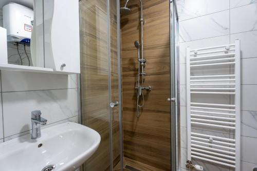a bathroom with a sink and a shower at 108 Lux Apartman Ravna planina in Gornje Pale