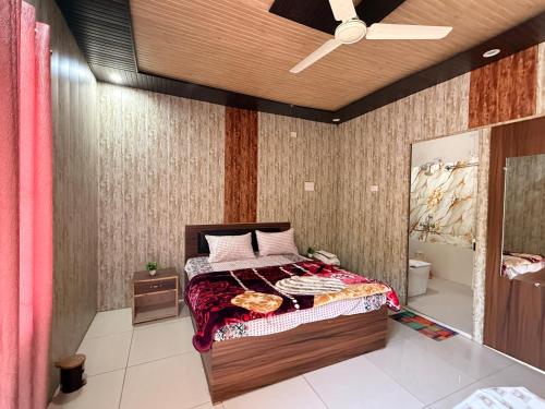 um quarto com uma cama e um ventilador de teto em Amangarh Corbett Farmstay em Rehar