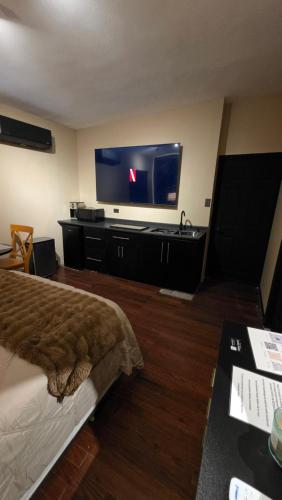 a hotel room with a bed and a flat screen tv at Luxury Suites Bangkok a 100 mts del consulado in Ciudad Juárez