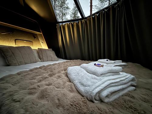 una camera da letto con un letto con asciugamani sopra di Arctic Bear Resort - Lapland - Aurora suite - Sauna - Northern Lights a Ranua