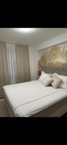 a large bed with white sheets and pillows at Sky Aslan Mostar in Mostar