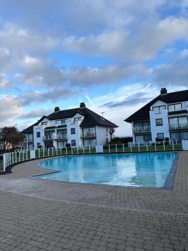a large swimming pool in front of two buildings at Let's Go Middelkerke in Middelkerke