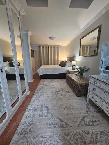 a bedroom with a bed and a dresser and a mirror at Villa Zoe in Glencairn