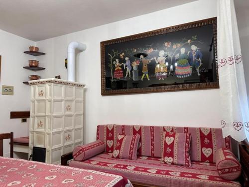 a living room with a couch and a painting on the wall at Casa Capon in Santo Stefano di Cadore