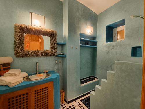 a bathroom with a blue sink and a staircase at La Douiria Essaouira Medina in Essaouira