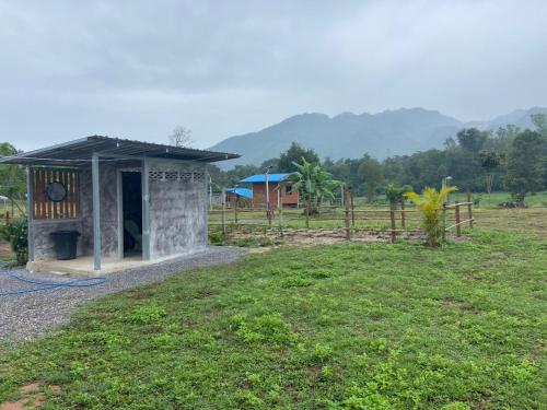 บ่อแก้วโฮมสเตย์的围栏,田野上的一座小建筑