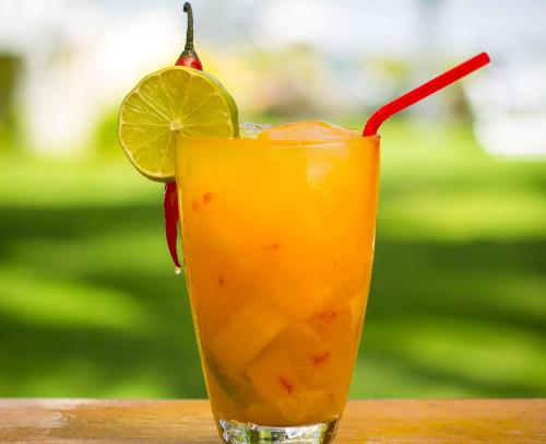 a drink with a lime and a red straw at Praiagogi Boutique Pousada in Maragogi