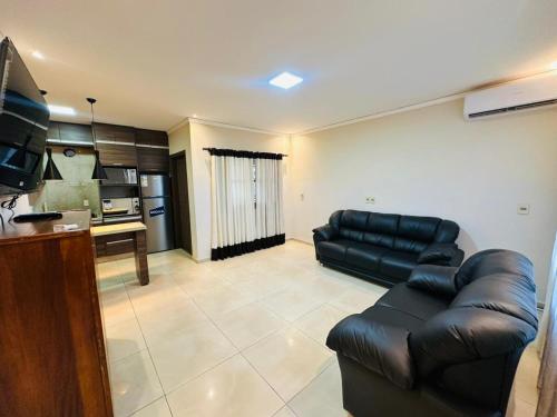 Casa Hohenau, Colonias Unidas في Hohenau: غرفة معيشة مع أريكة جلدية ومطبخ
