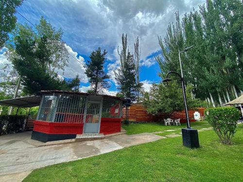a red building with a gate in a yard at Complejo el trébol in Potrerillos