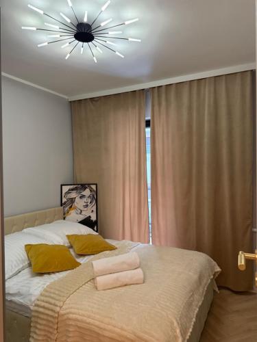 a bedroom with a large bed with a chandelier at Apartament Comfort Wrocław in Wrocław