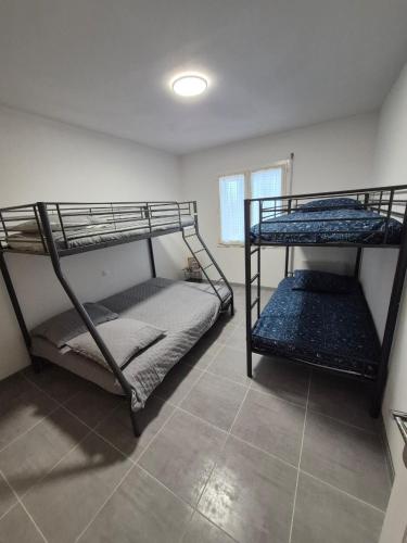 two bunk beds in a room with a window at Gîte OL'HERON familiale pour 9 personnes à Dolus in Dolus-d'Oléron