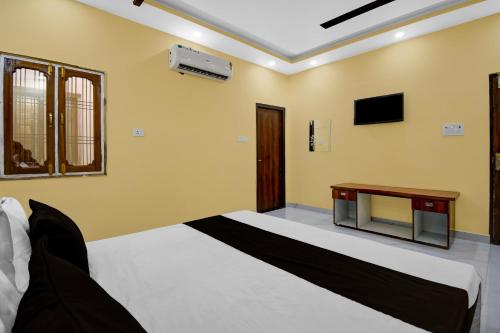 ein Schlafzimmer mit einem Bett und einem Fernseher an der Wand in der Unterkunft Hotel O DP Palace in Banthra Sikandarpur