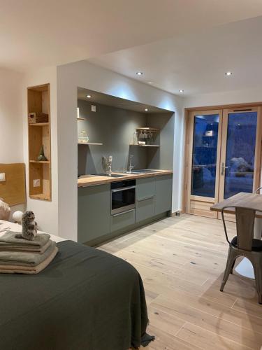 cocina con cama y mesa en una habitación en La marmotte qui papote, en Le Grand-Bornand