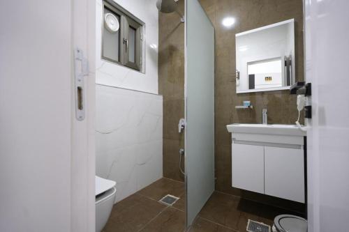 a bathroom with a toilet and a sink and a mirror at Zenia Motel in Erbil