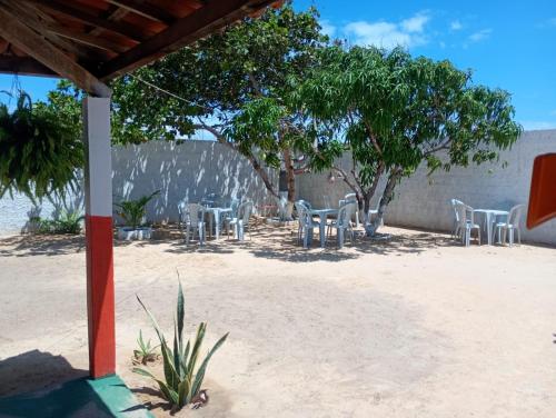 - un groupe de tables et de chaises sur la plage dans l'établissement Hostel Mamitchesca - Redes e Barracas, à Aracati