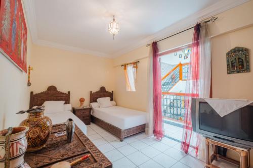 马拉喀什Riad Palm Oasis Marrakech的带电视和沙发的客厅