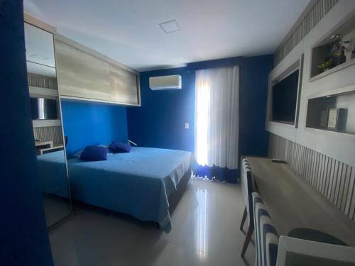 ein blaues Schlafzimmer mit einem Bett und einem Fenster in der Unterkunft Hotel em CABO FRIO Cond Royale - Av N S Assunção 239, bairro Passagem - un 229 in Cabo Frio