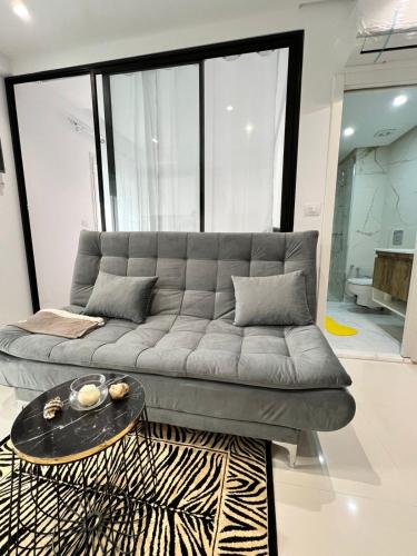 a living room with a gray couch and a table at Appartement à louer in Sousse