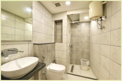 a white bathroom with a sink and a toilet at Hotel THE RB Near Jagannath Temple And Sea Beach - Parking- Spa With Restaurant - SWIMMING POOL Facilities - Fully Air Conditioning Deluxe Rooms - Prime Location in Puri