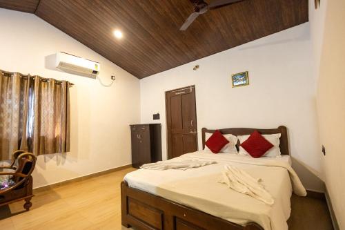 Nature Bloom Resort في Paror: غرفة نوم بسرير ومخدات حمراء