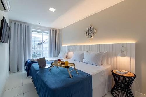 een hotelkamer met een bed met daarop een laptop bij Lindo Apto, Prédio beira mar c/ Piscina e Hidro in Cabo Frio