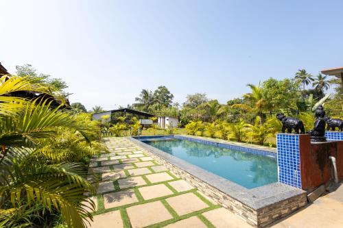 Nature Bloom Resort في Paror: حمام سباحة في منتجع مع تماثيل بجانبه