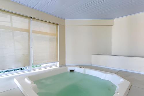 een wit bad in een kamer met een raam bij Lindo Apto, Prédio beira mar c/ Piscina e Hidro in Cabo Frio