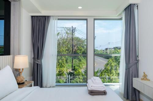 ein Schlafzimmer mit einem Bett und einem großen Fenster in der Unterkunft Phuket Family apartment in Phuket