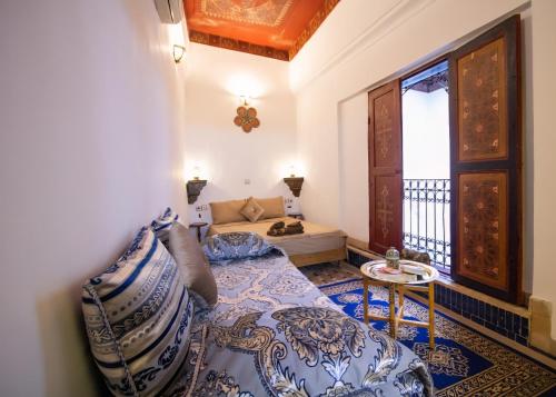 a room with a bed and a couch and a window at Riad BAB JDID in Fès