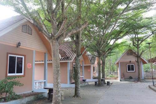 een roze huis met bomen ervoor bij คันทรี รีสอร์ท 