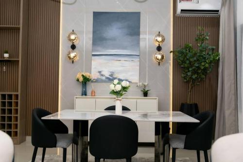 uma sala de jantar com uma mesa e cadeiras brancas em Wrightfield em Lagos